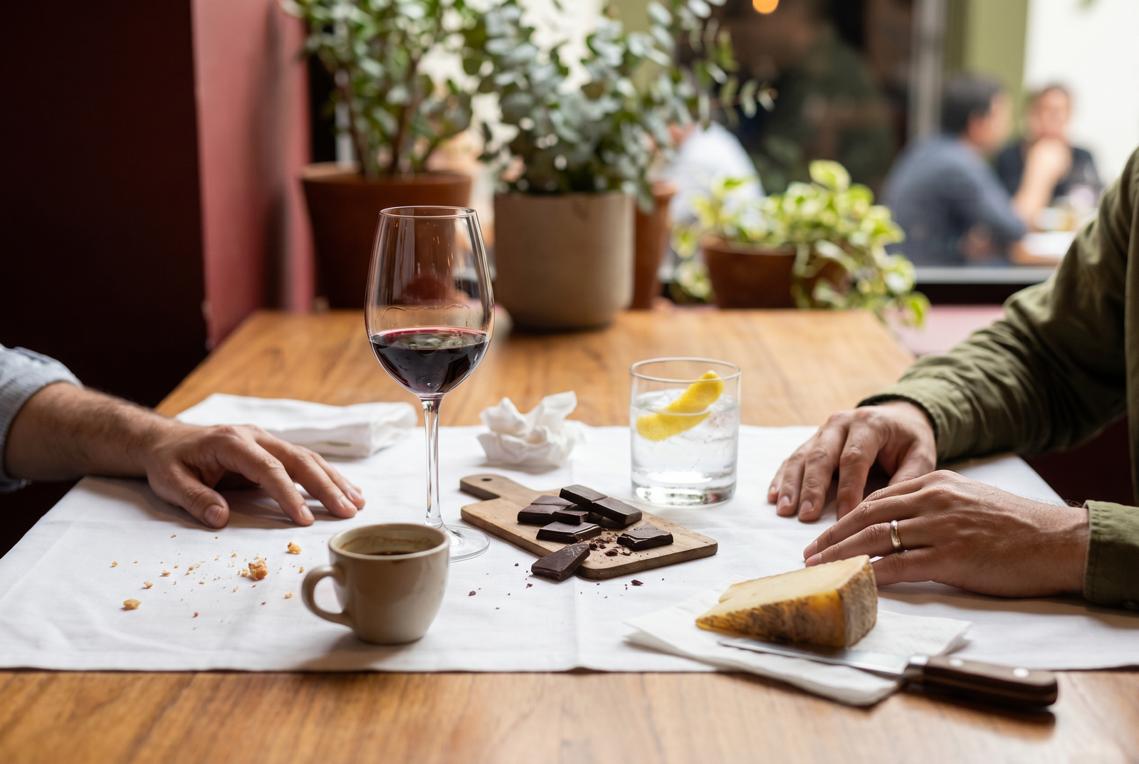 Mesa de sobremesa en Lima con copas de vino tinto, gin tonic y café después de comer