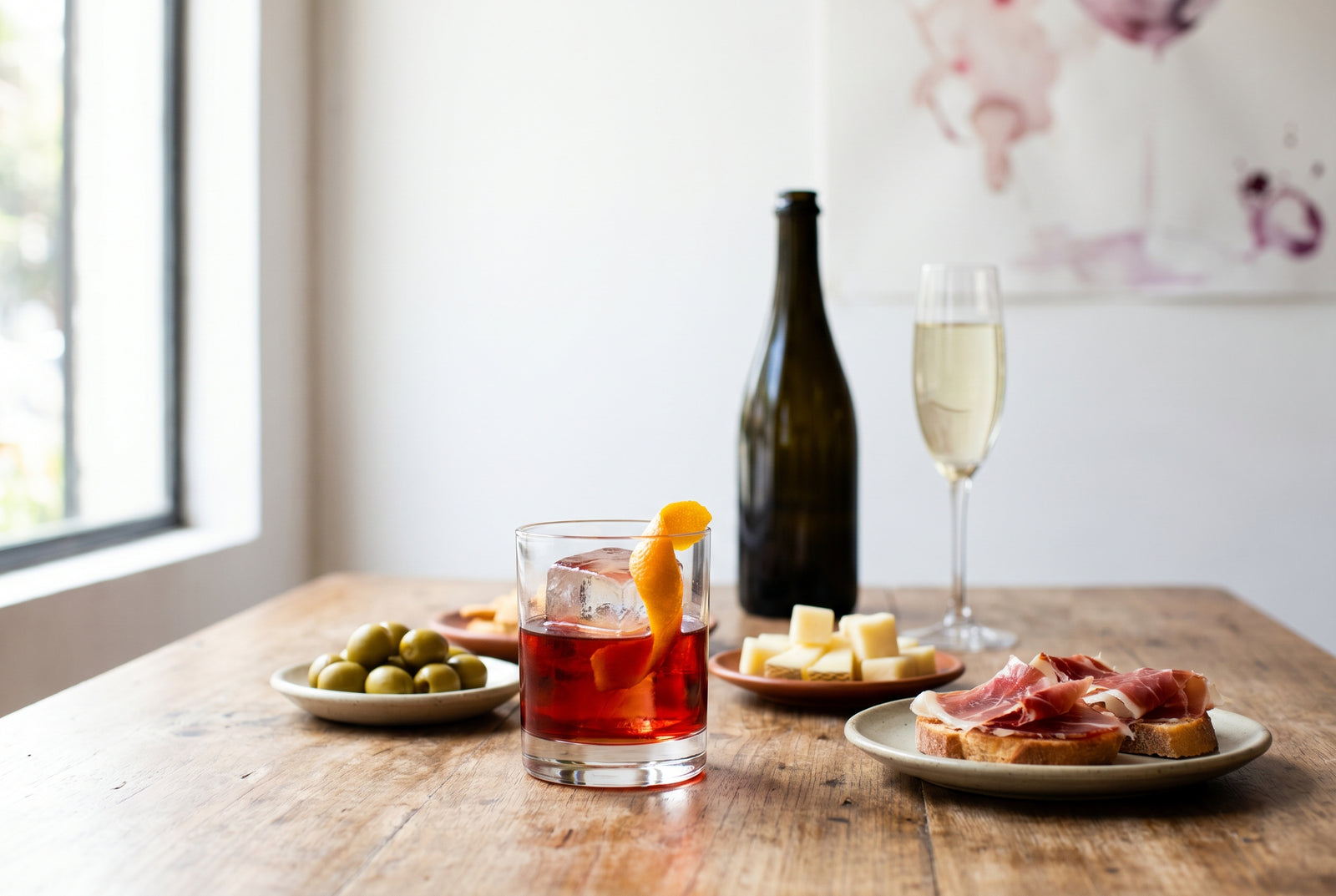 Vermut rojo con hielo, piel de naranja, aceitunas y tapas en una barra luminosa de Lima