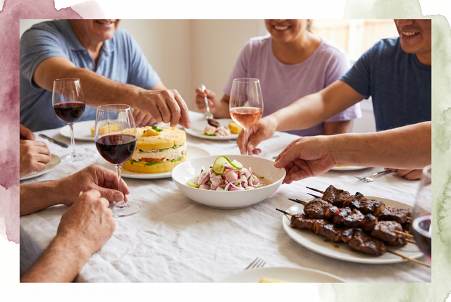 Mesa de Fiestas Patrias en Lima con anticuchos, causa y cebiche junto a copas de vino tinto y rosado, bajo luz cálida y natural.